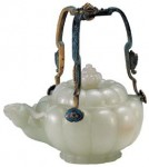 An imperial jade pot with a handle, used by Emperor Jiaqing (1796—1820) of the Qing Dynasty with a height of 10.5 cm and a diameter at the opening of 8.5 cm. The handle height is 10.4 cm