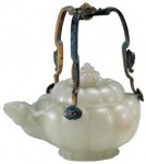 An imperial jade pot with a handle, used by Emperor Jiaqing (1796—1820) of the Qing Dynasty with a height of 10.5 cm and a diameter at the opening of 8.5 cm. The handle height is 10.4 cm