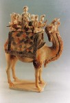 A Tang-triple-color ceramic camel that carries a small musical band on its back with a female performer standing in the middle singing and dancing